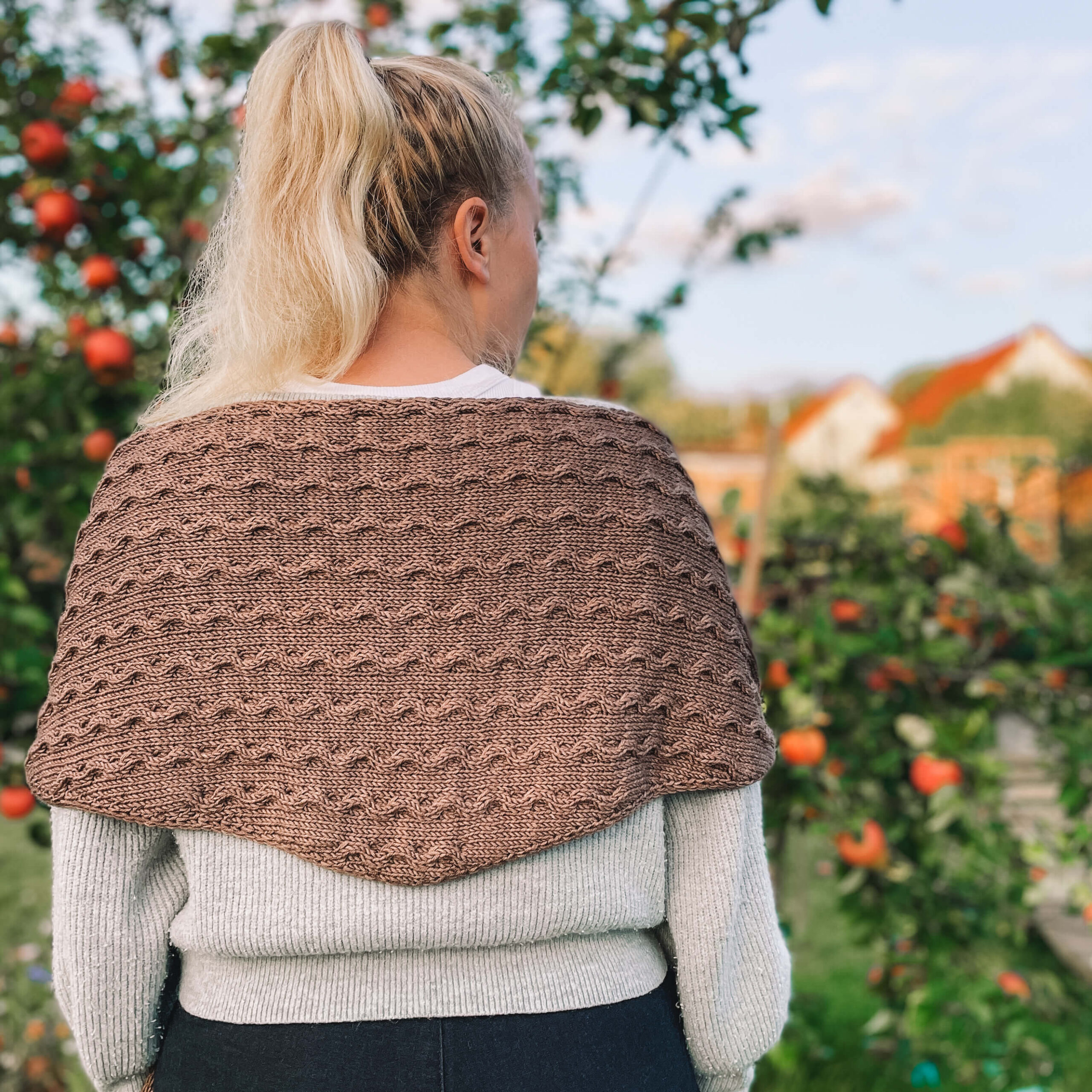 Photograph of Katharina Lehmann wearing her new knitting pattern design: the Hazelnut Shawl.